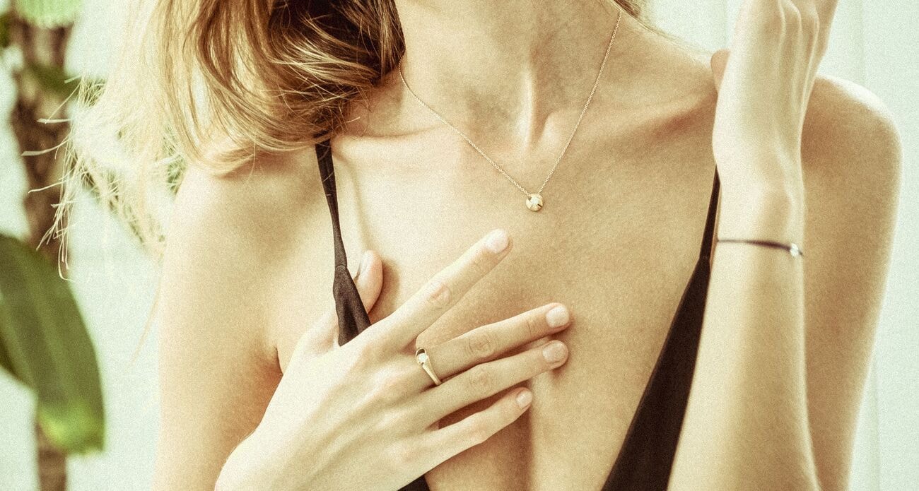 Frau mit feiner Halskette, Ring und Armband