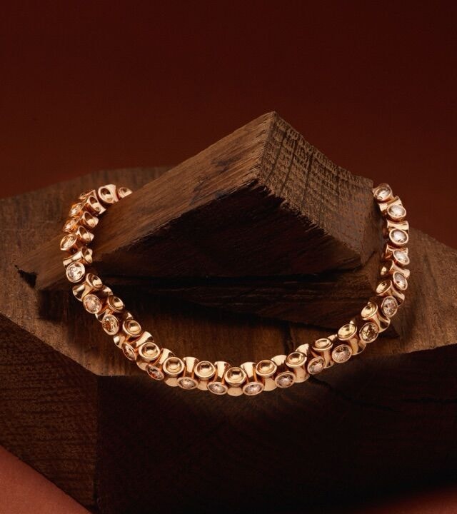Armband der Linie Le Tonneau mit naturbraunen Diamanten auf einem dunklen Holzblock